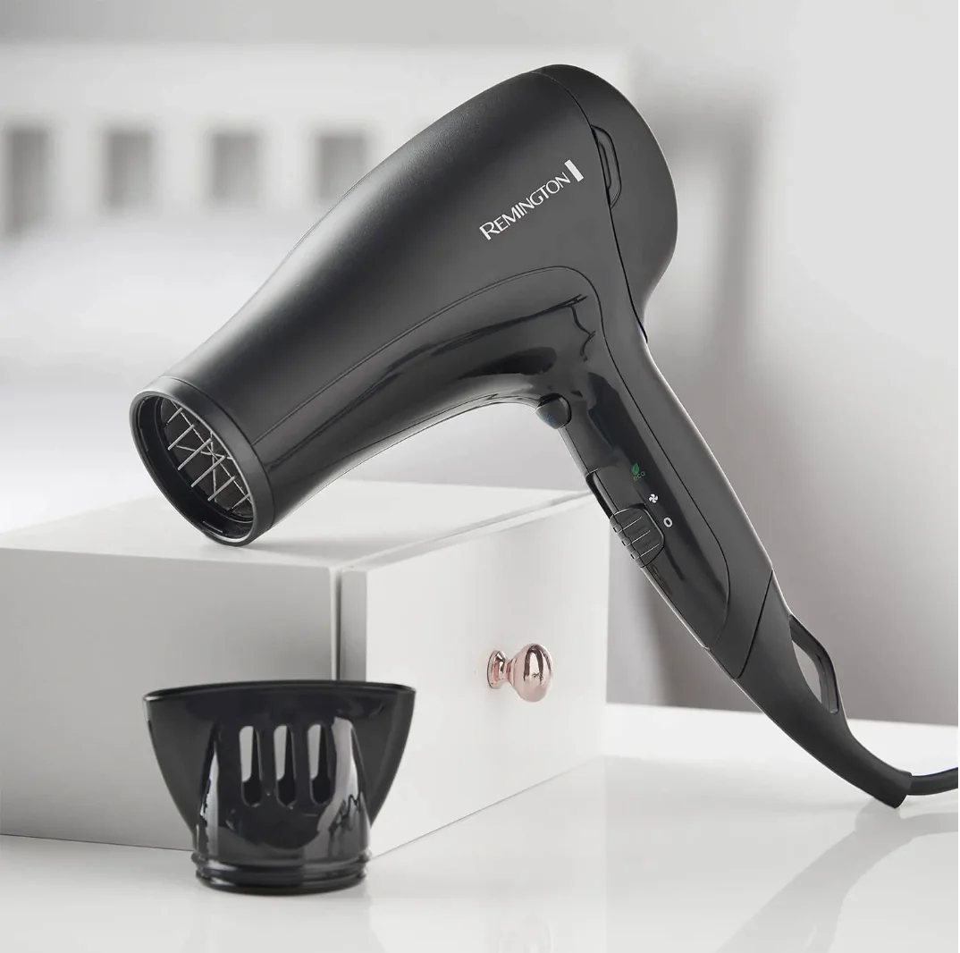 A modern Remington hair dryer, white plastic, with a bulky handle and rounded body, photographed for the teardown project