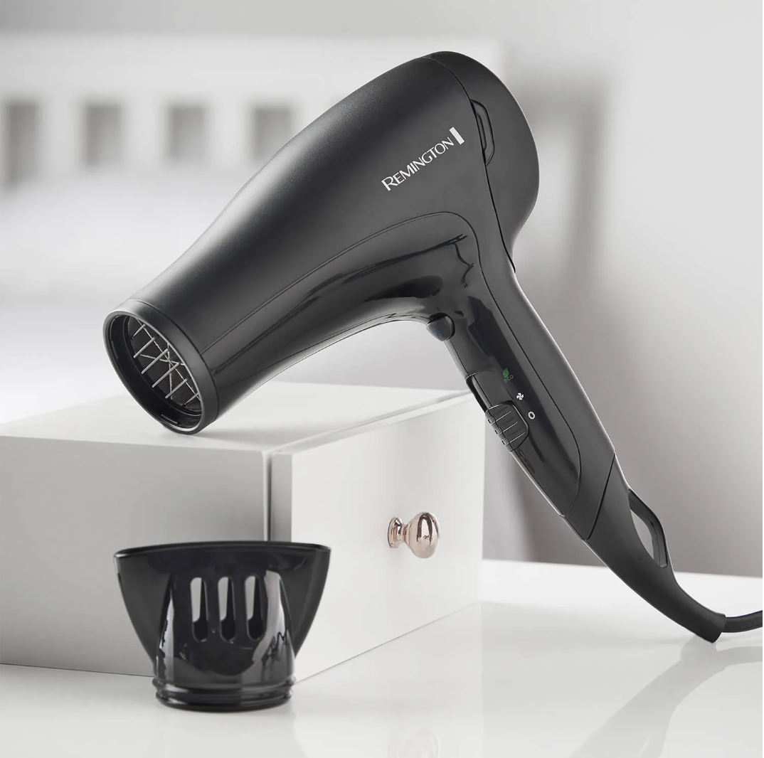 A modern Remington hair dryer, white plastic, with a bulky handle and rounded body, photographed for the teardown project