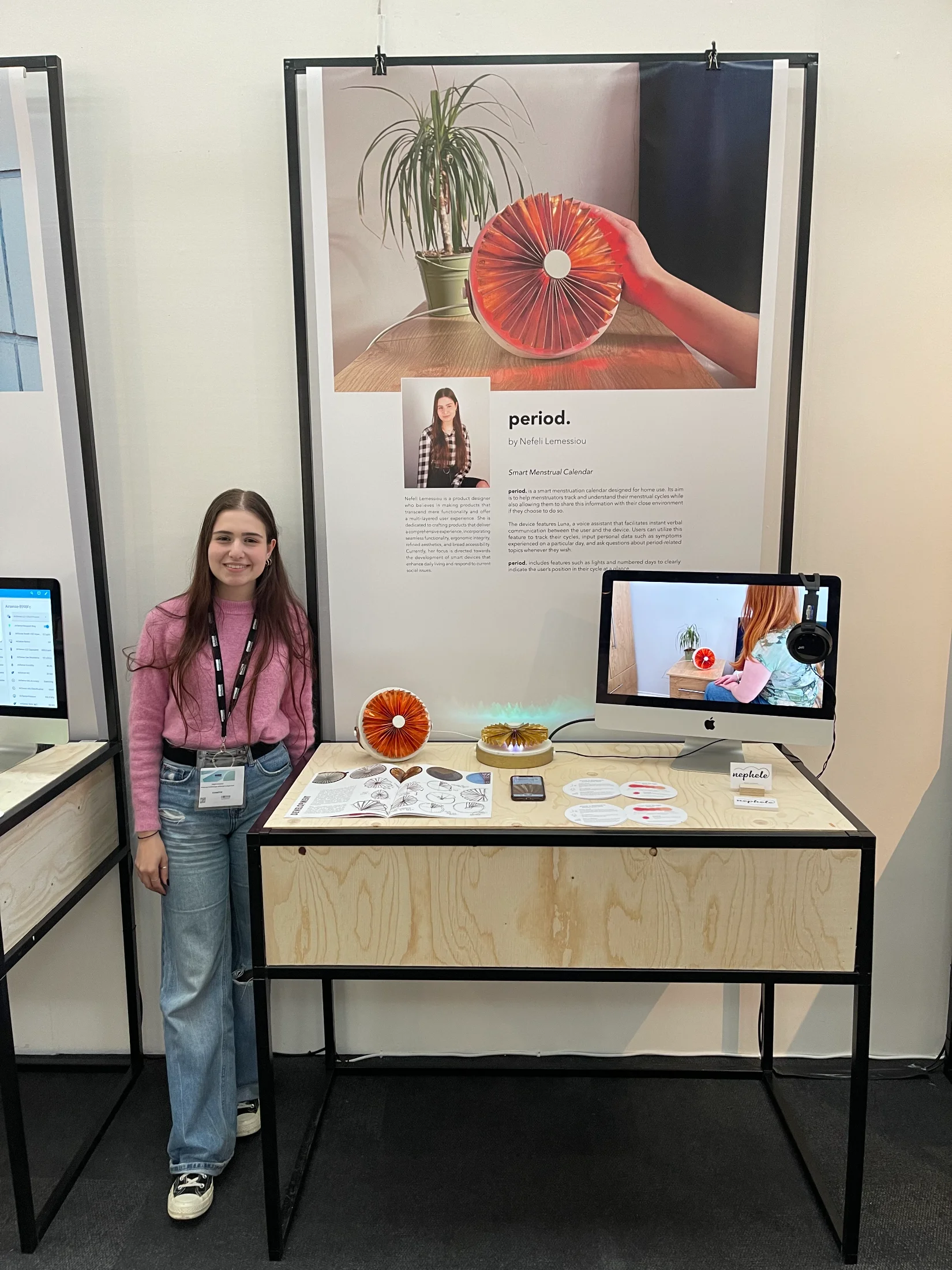 Nefeli at her period. stand at New Designers, with the device, supporting materials, a demo video and project poster behind
