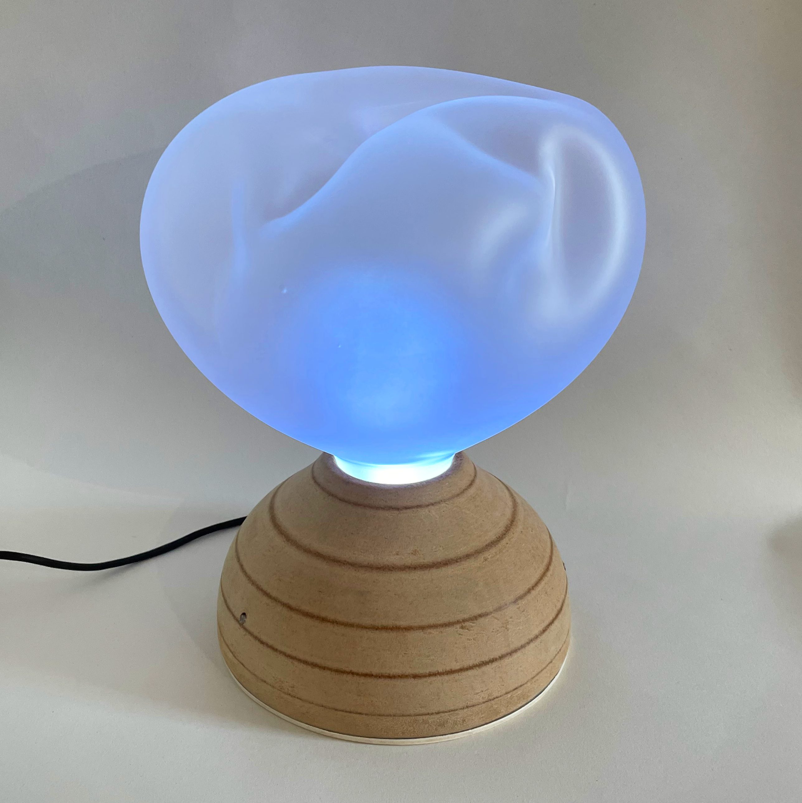 Ilia glowing blue during a breathing cycle on the wooden dome base