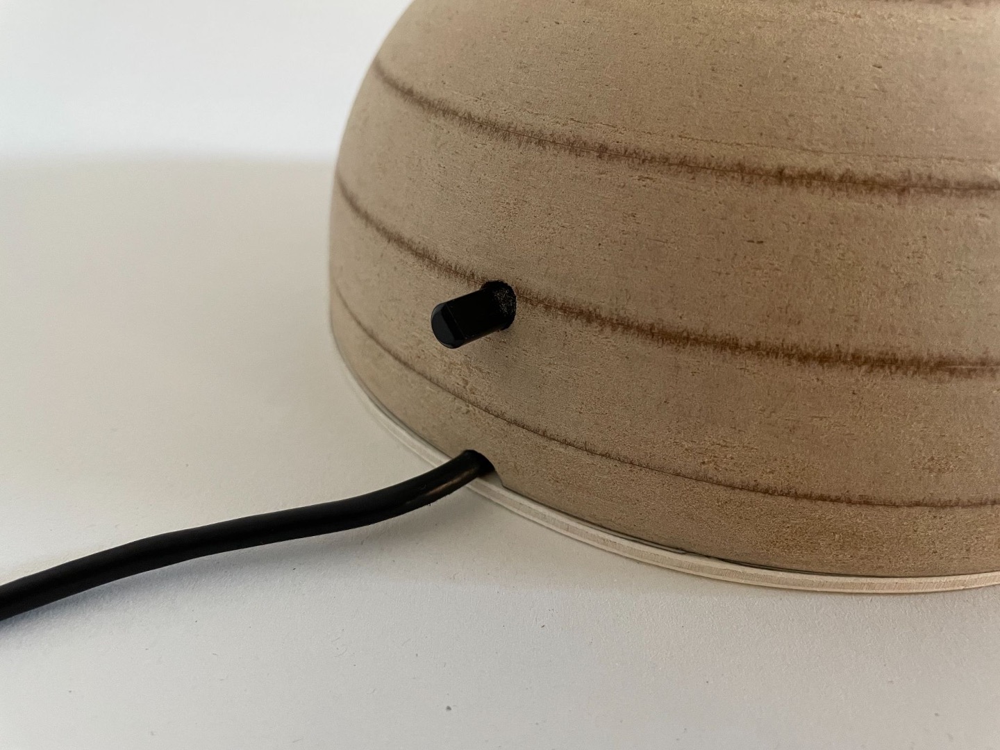 Detail of the side power switch tucked into the turned wooden base