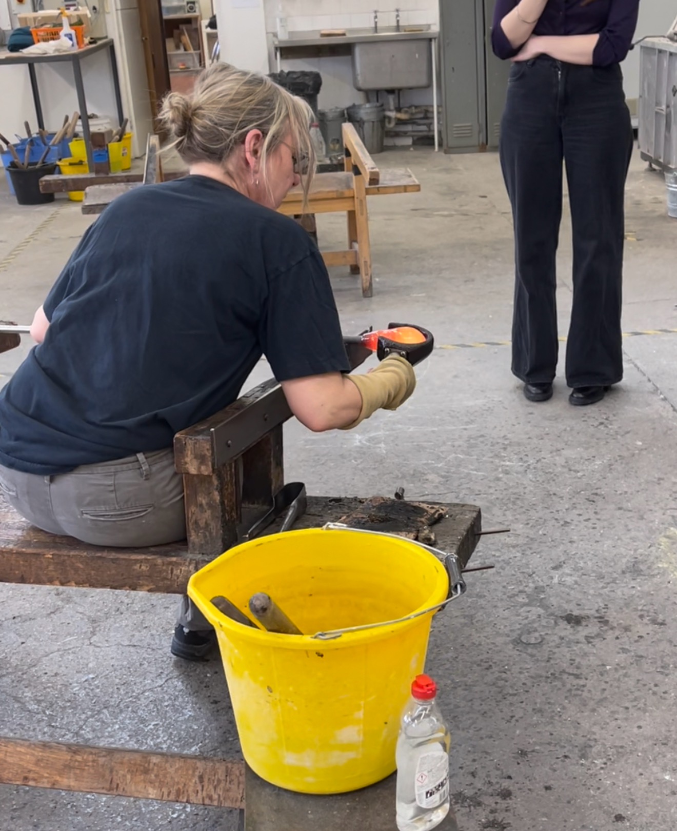 Hot glass being blown and shaped with wooden rods to create the cloud-form diffuser