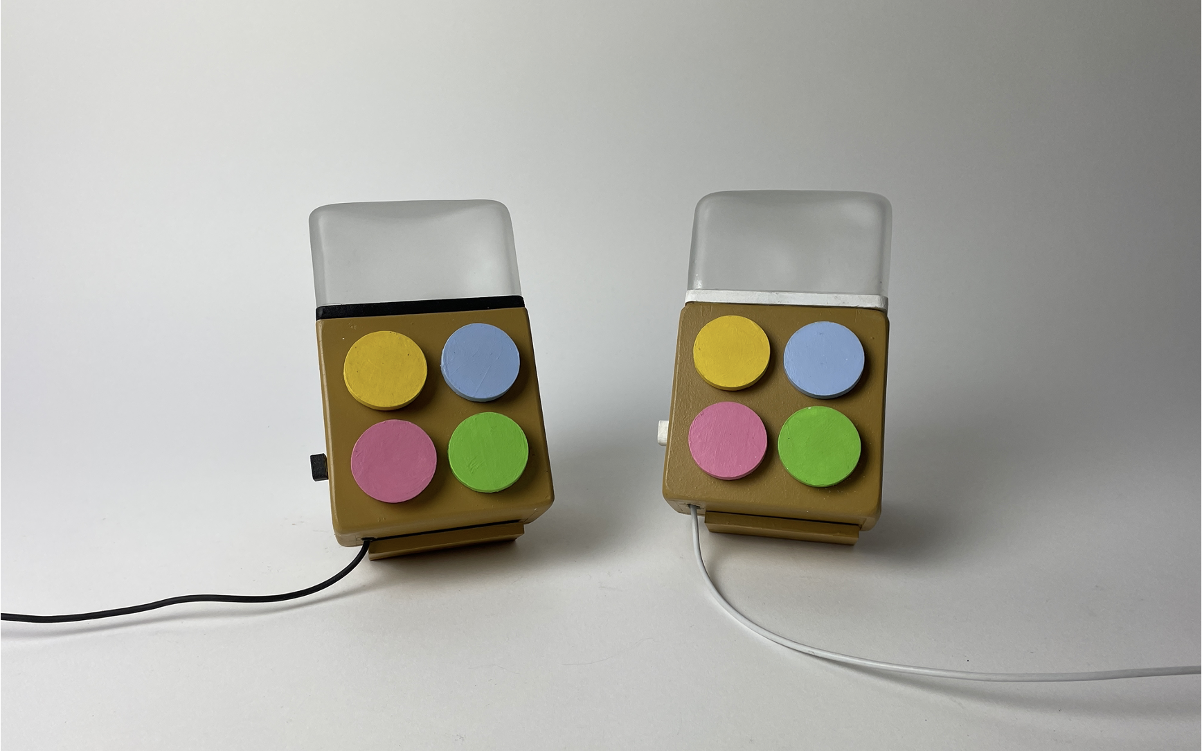 The Milo pair, two small wooden devices with four pastel buttons and a glass-blown diffuser top, sitting side by side