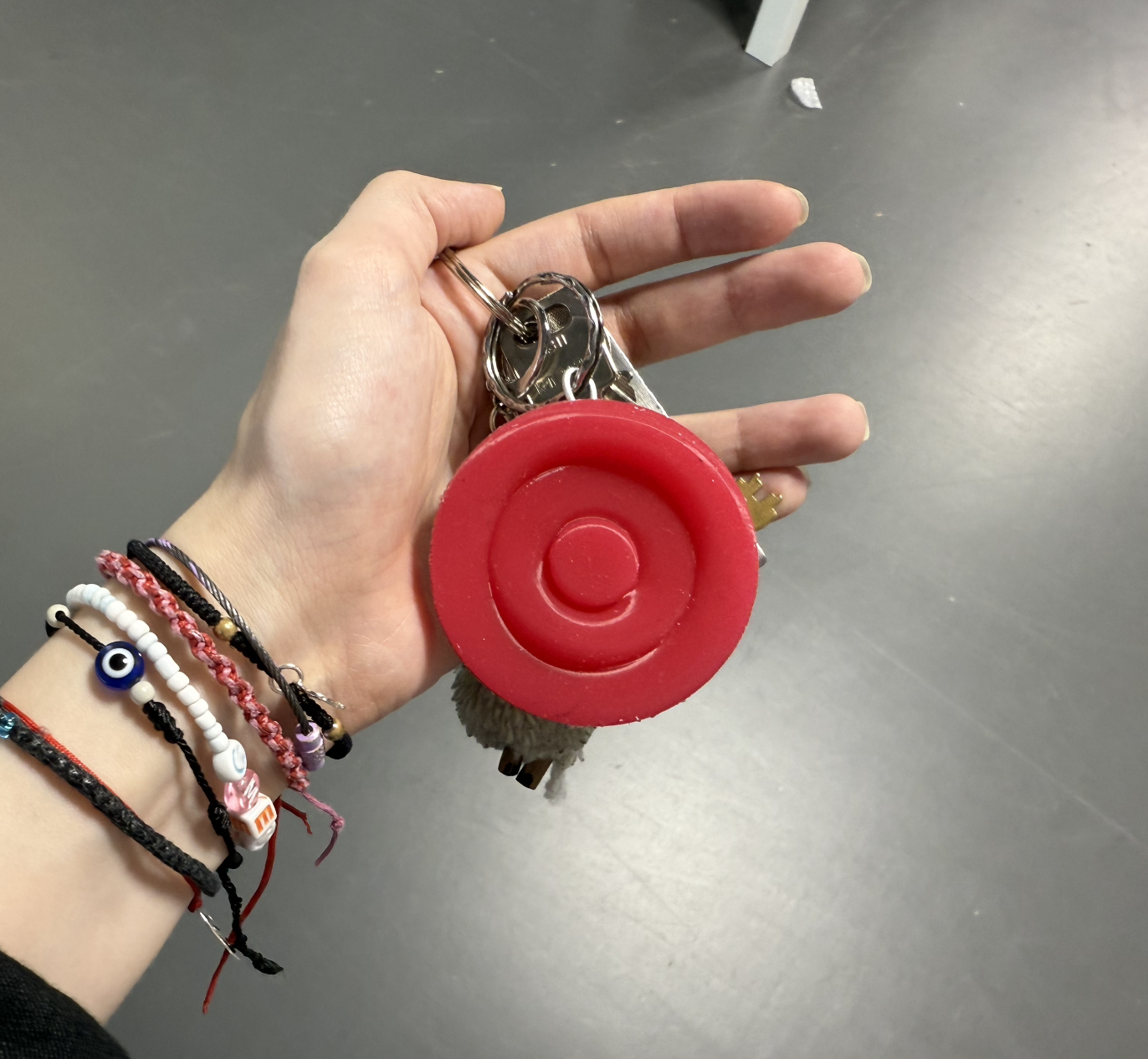 The red Onaka device on a keychain, held in a hand