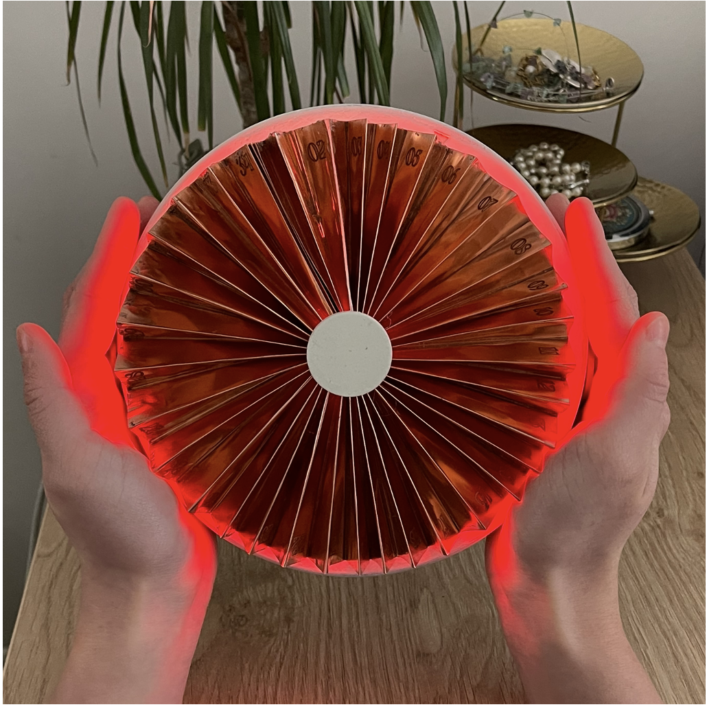 The fan glowing red on a bedside table