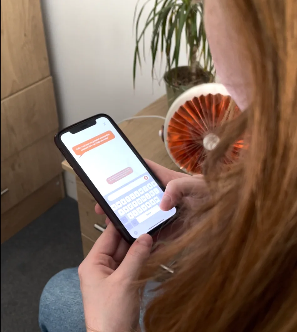 Typing a question to Luna in the app, with the copper device on the desk behind