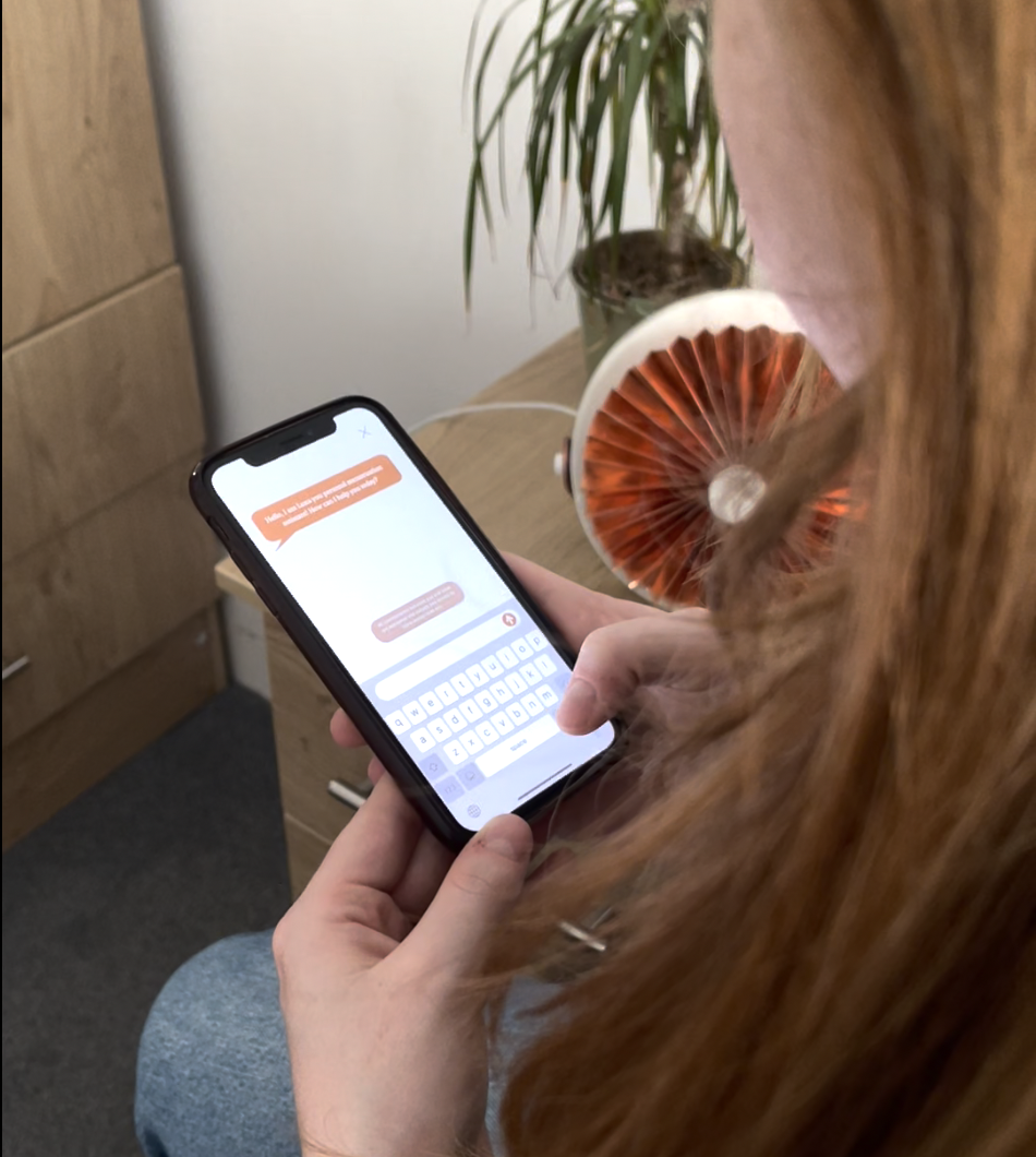 Typing a question to Luna in the app, with the copper device on the desk behind