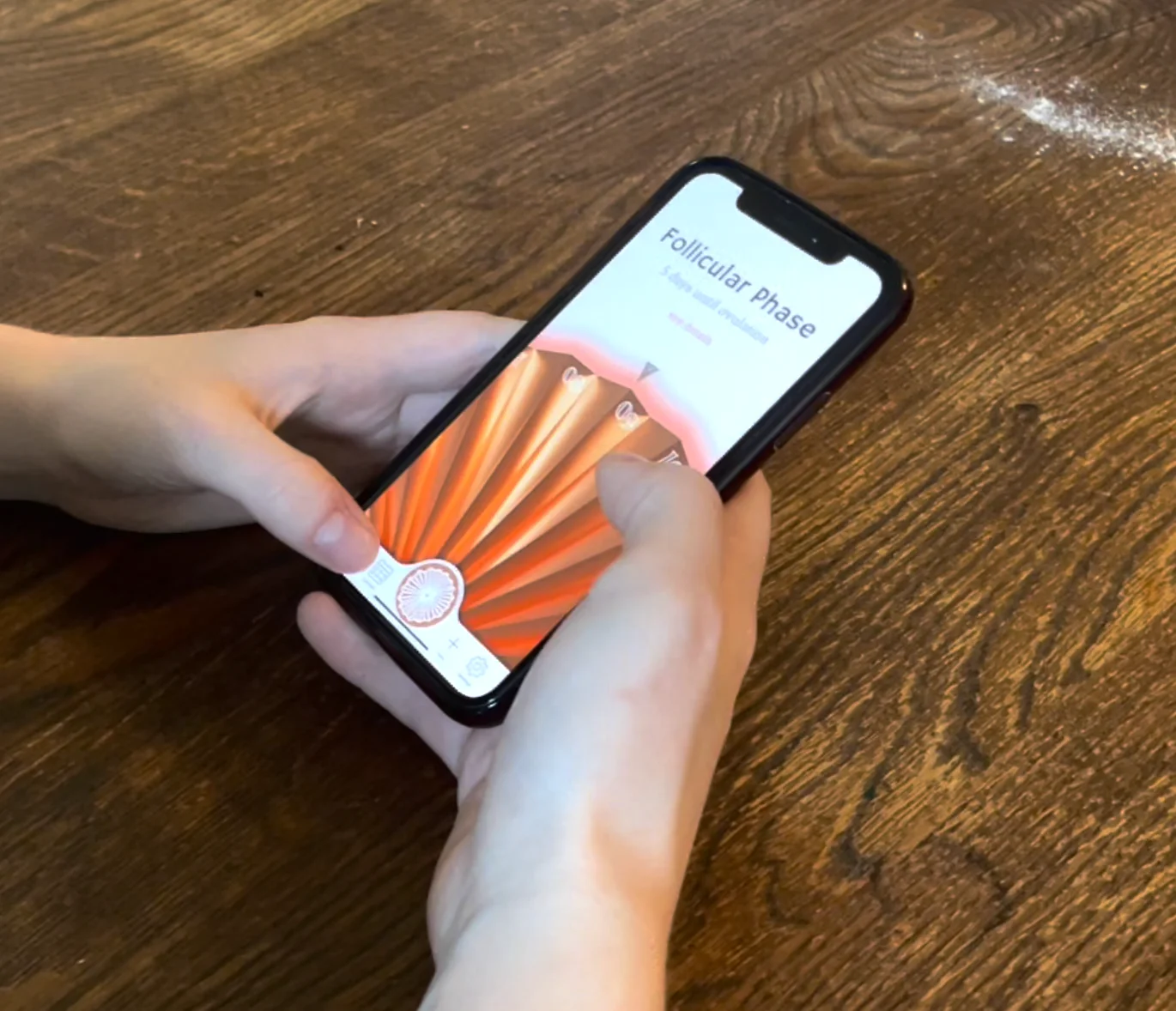 Two hands holding the phone away from the bedside, home screen open