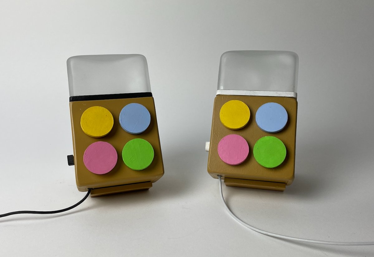 The Milo pair photographed front-on: two small wooden boxes with frosted glass tops and four pastel buttons each